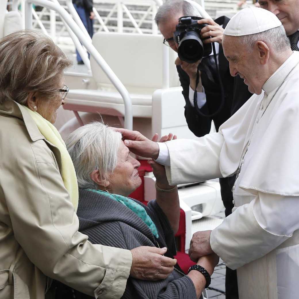 Pope Francis greets an elderly woman in a wheelchair